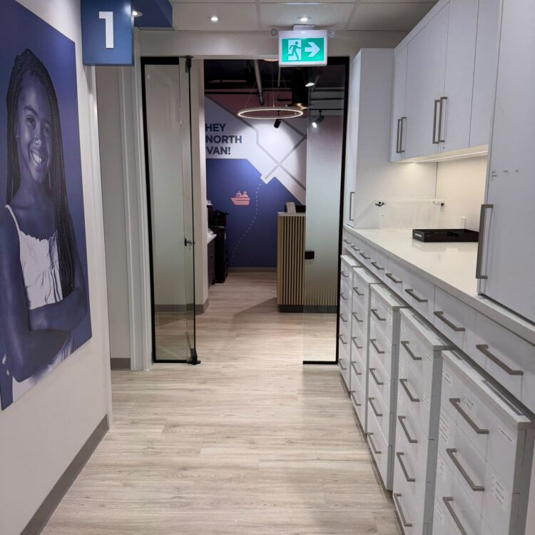 Clinic hallway beside treatment room 1 leading to the Hey North Van reception wall at Smili Dental