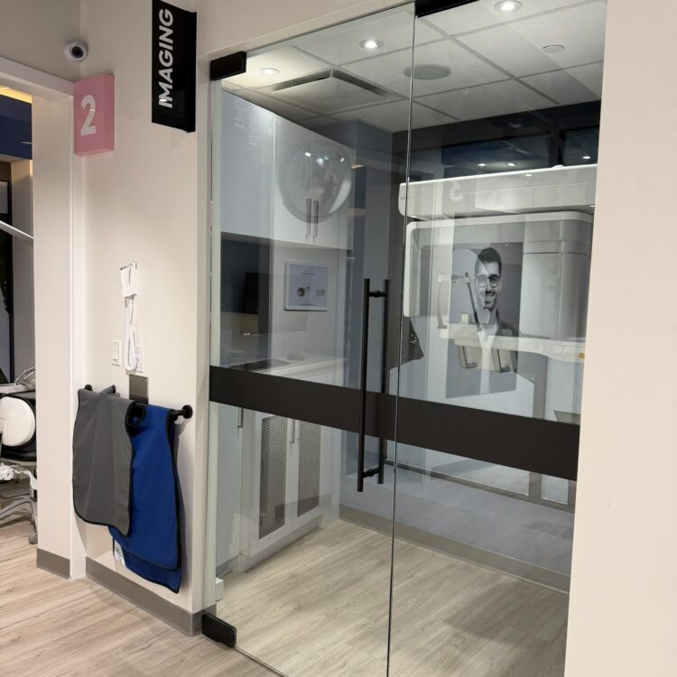 Glass-walled dental imaging room with lead aprons at Smili Dental