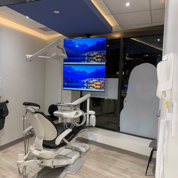 Dental treatment room with patient chair and dual screens at Smili Dental North Vancouver