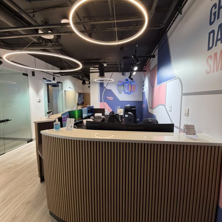 Modern reception desk with wood slat panelling and ring lights at Smili Dental in North Vancouver